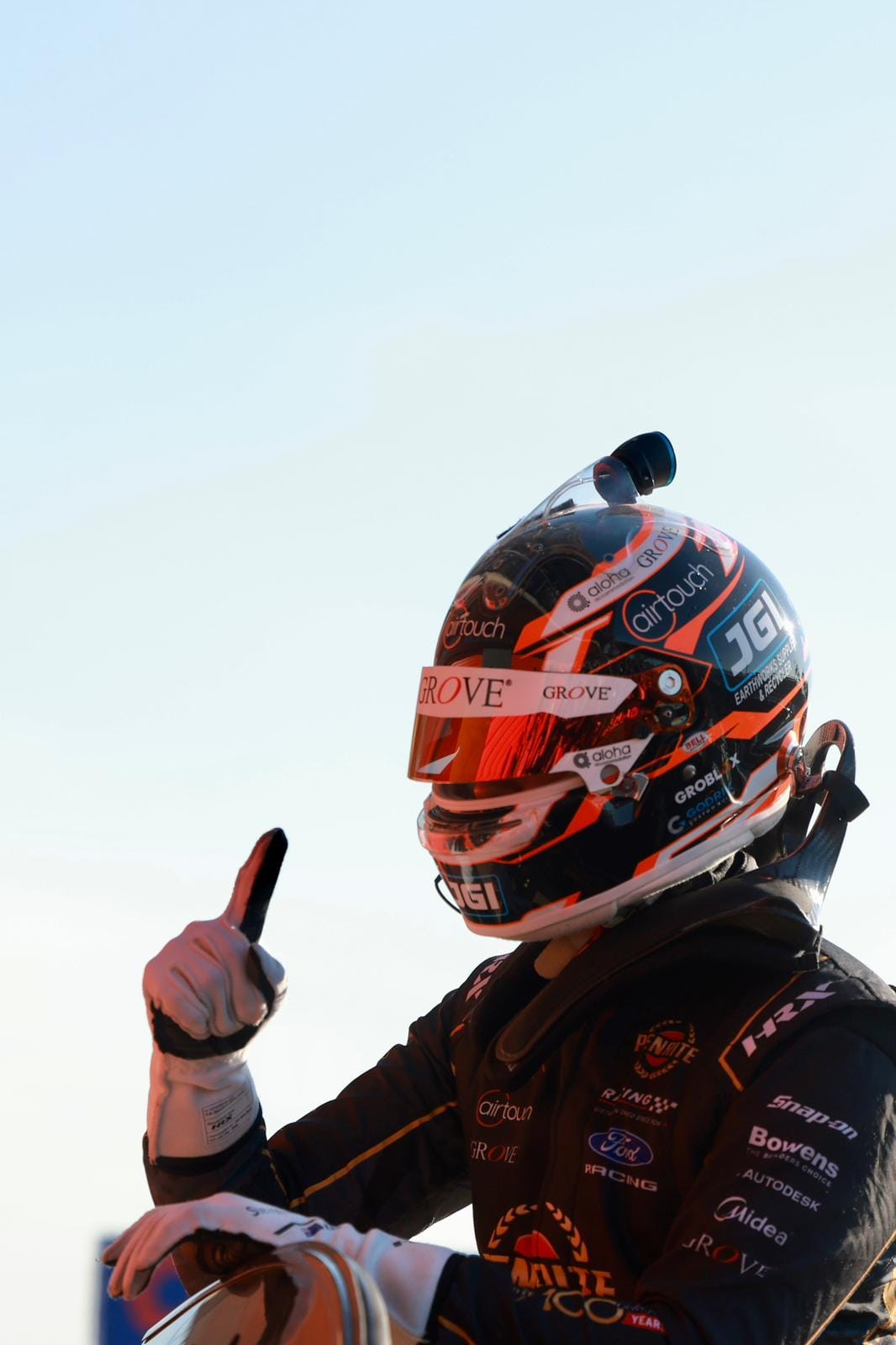 A Penrite Racing driver gives a thumbs up while wearing a helmet after racing at Hidden Valley Raceway.