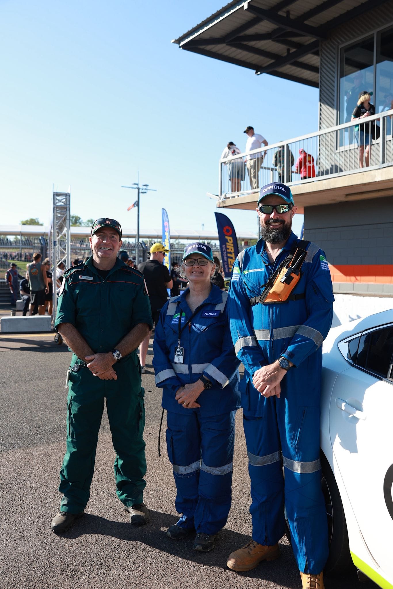 Emergency and medical officials pose beside a vehicle in pit lane at Hidden Valley Raceway during Darwin Supercars.