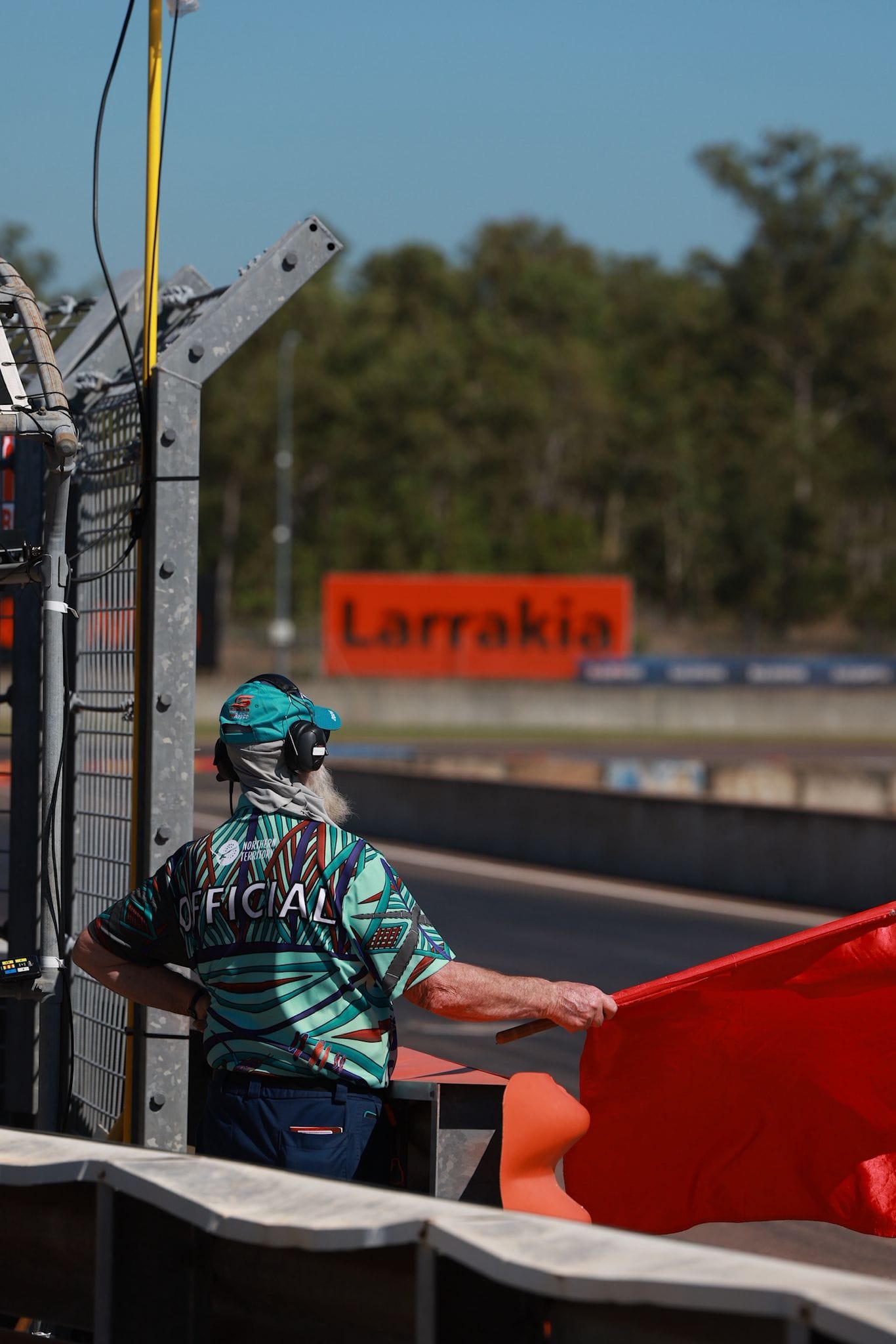 Official with an orange flag on the side of the Hidden Valley track at the Darwin Supercars event