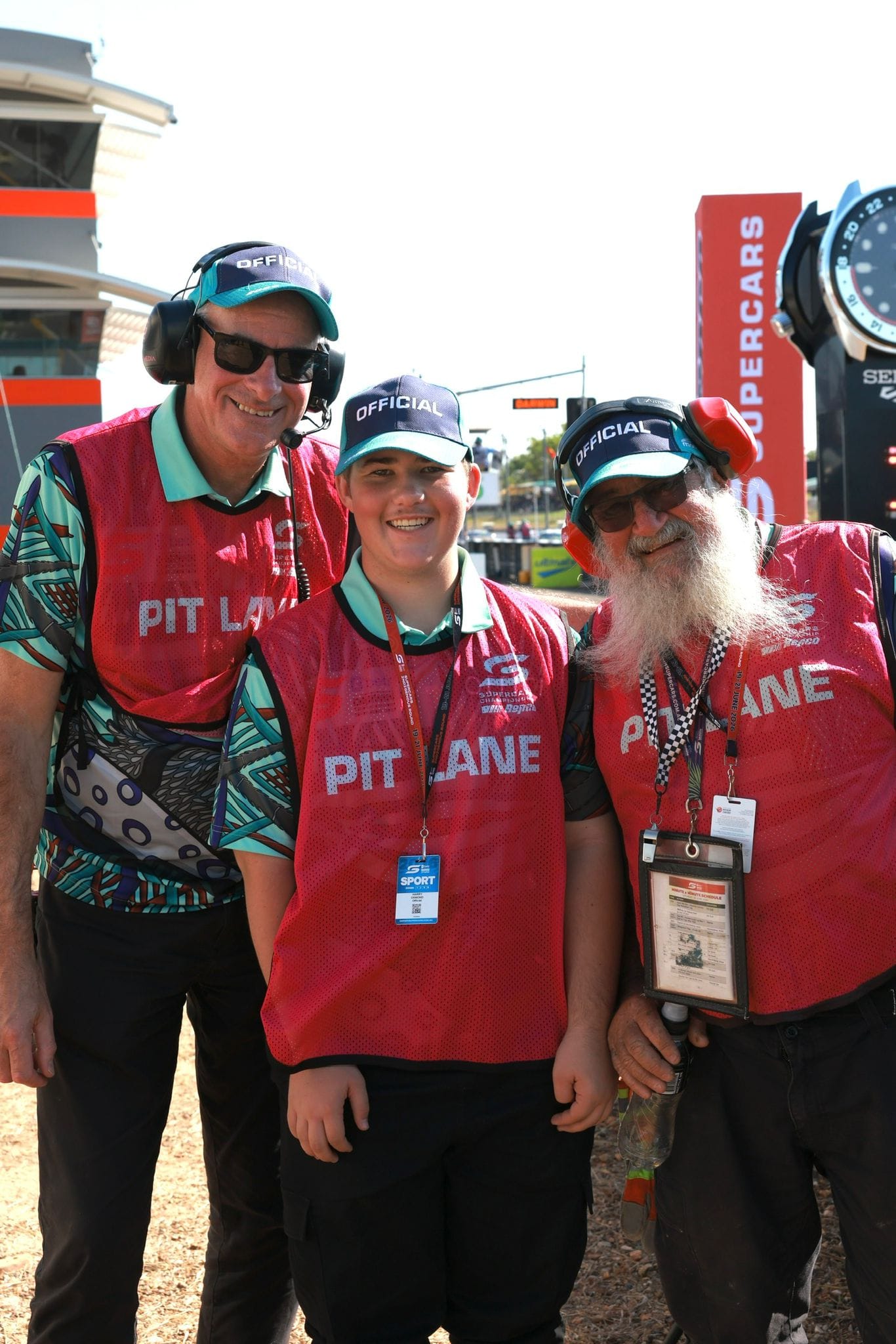 Three pit lane officials smile for a photo near the track at Darwin Supercars.