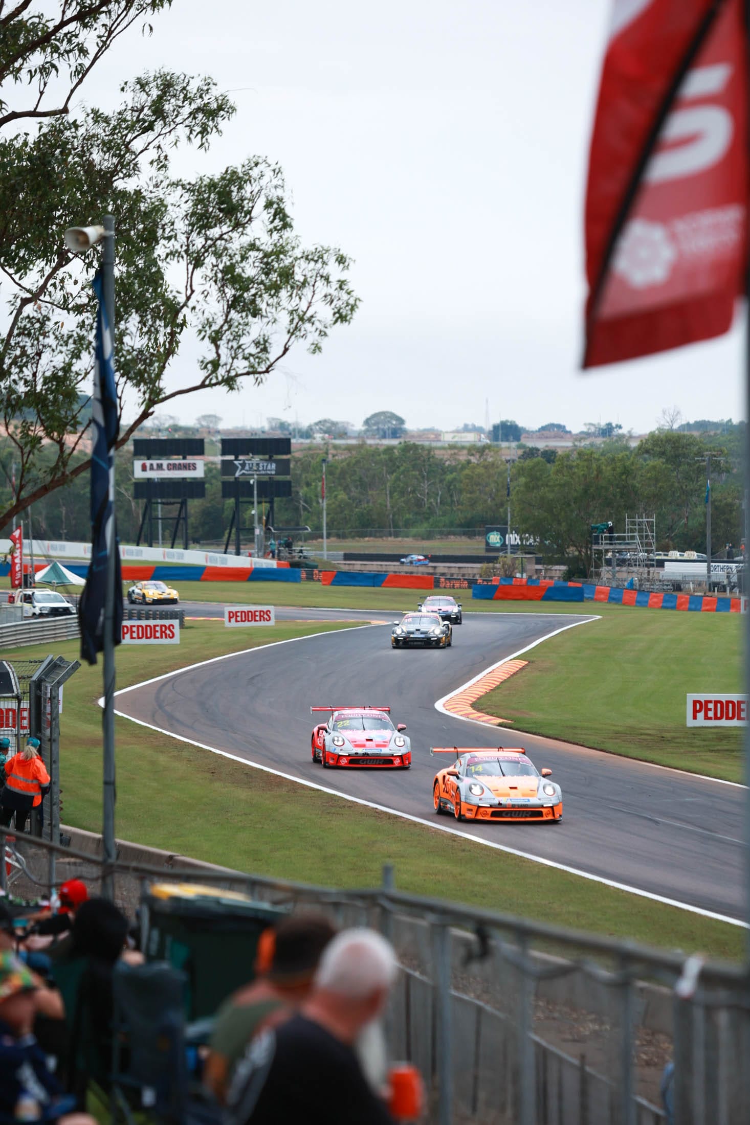 Porsche race cars driving through a bend at Hidden Valley Raceway during a support category race.