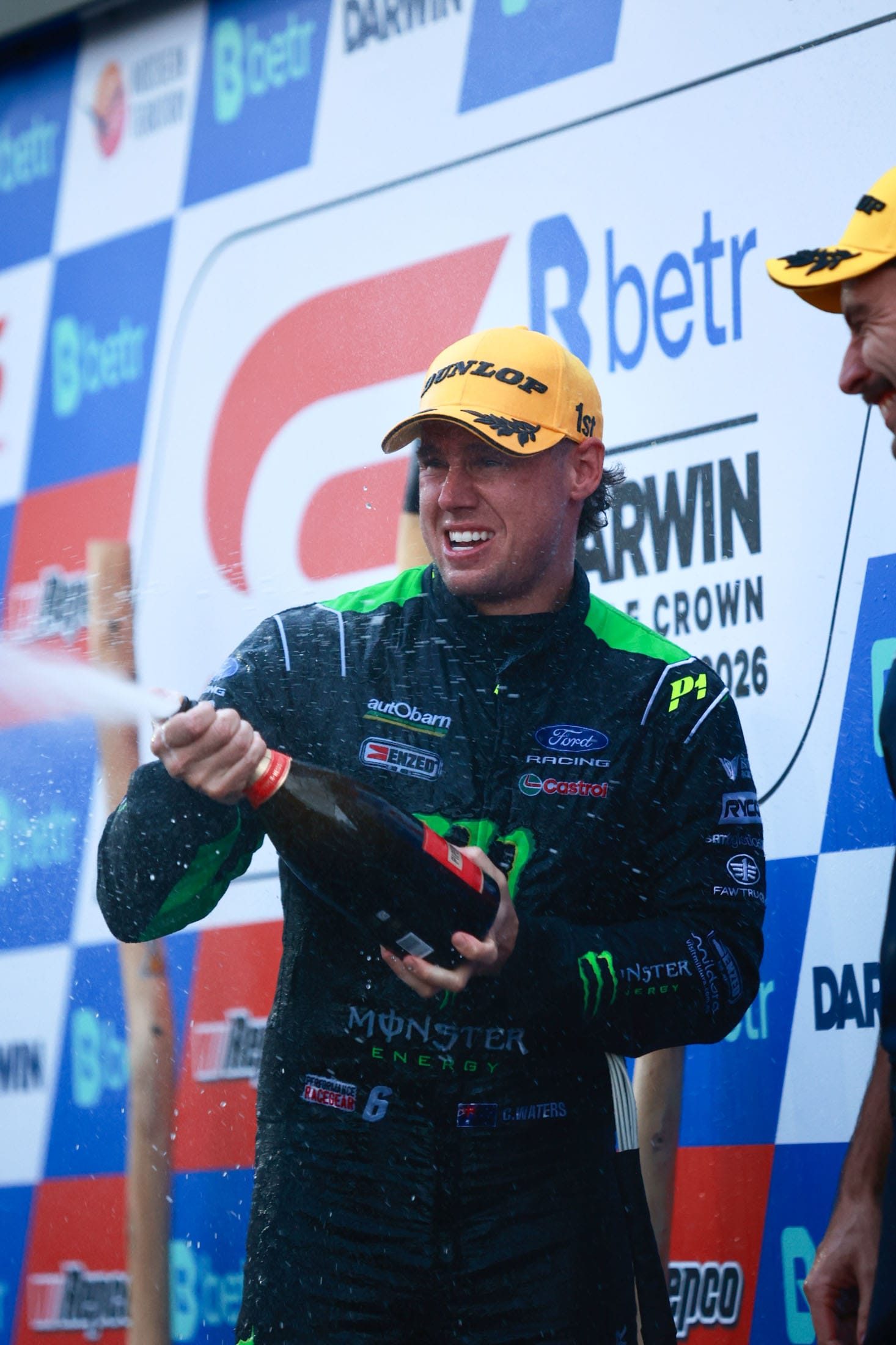 Monster Energy driver celebrating on the Darwin Triple Crown podium with champagne.
