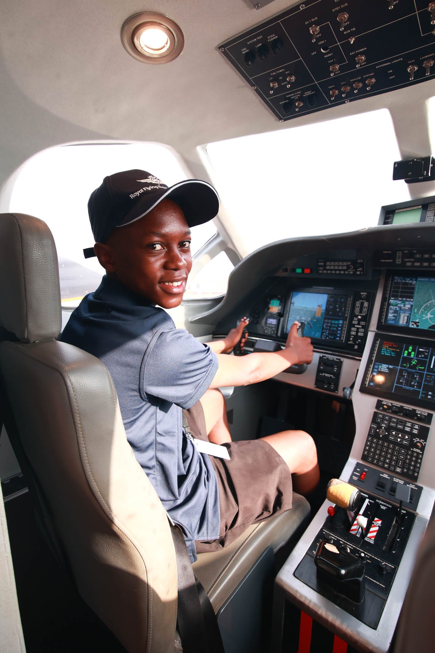 A child sitting in the cockpit of a Royal Flying Doctor Service aircraft display at Hidden Valley Raceway.
