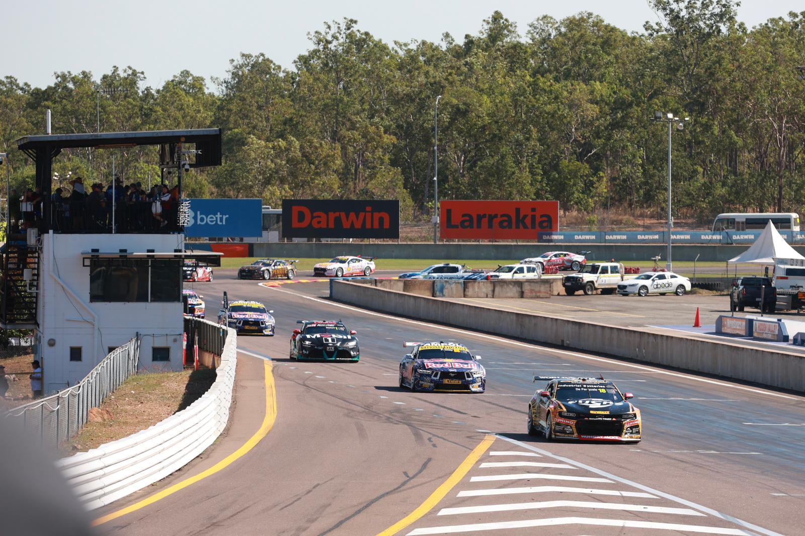 Supercars race along the main straight at Hidden Valley Raceway, with Darwin and Larrakia signage in the background.