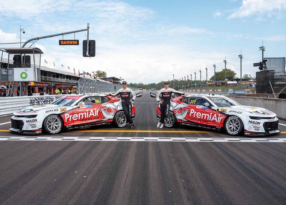 Two drivers standing beside PremiAir Racing Supercars on the Hidden Valley Raceway start line in Darwin.