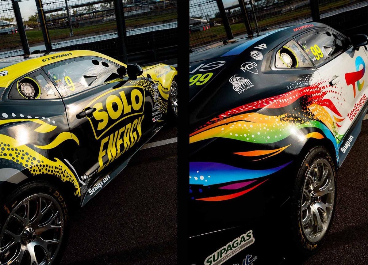 Side-by-side close-up of two Erebus Motorsport Supercars showing Solo Energy and TotalEnergies liveries on pit lane.