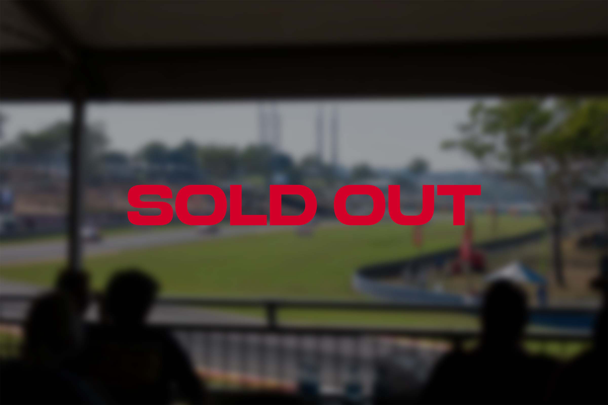 Red text showing SOLD OUT with a blurred image behind it with people watching a racing track in a grandstand